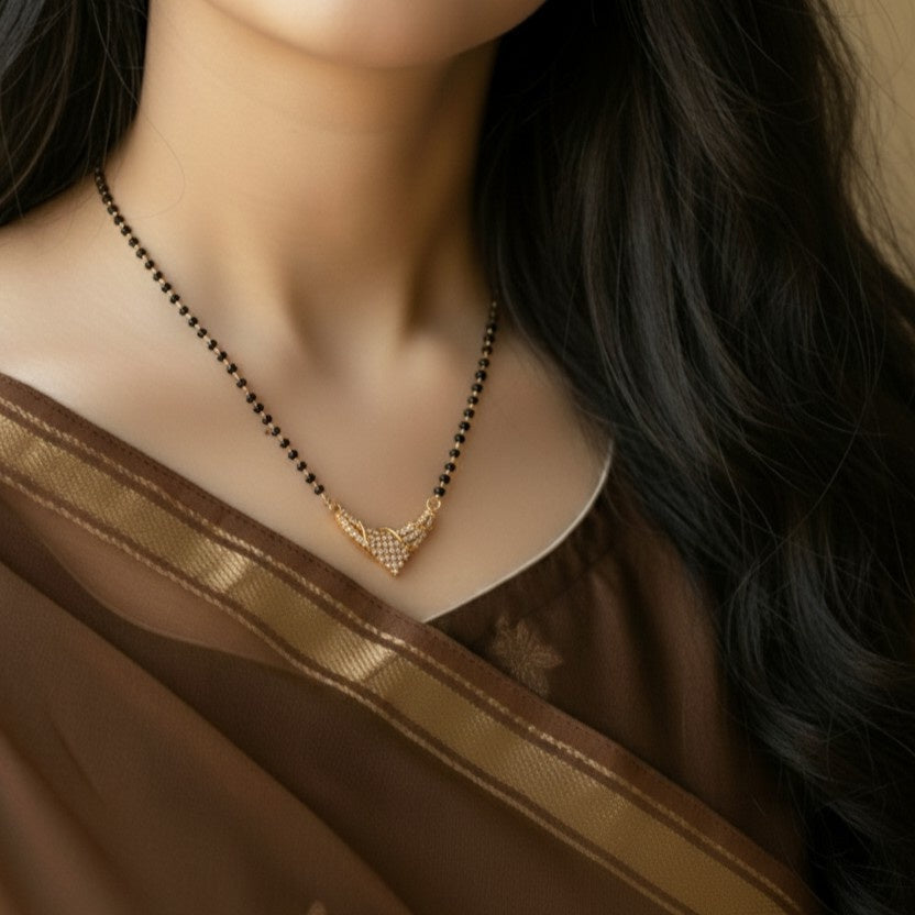 Woman wearing a gold necklace with a brown saree