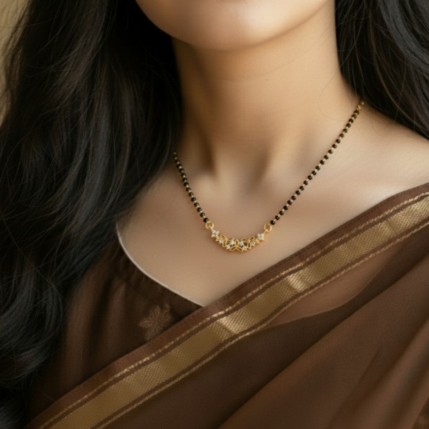 Woman wearing a gold necklace with a brown saree