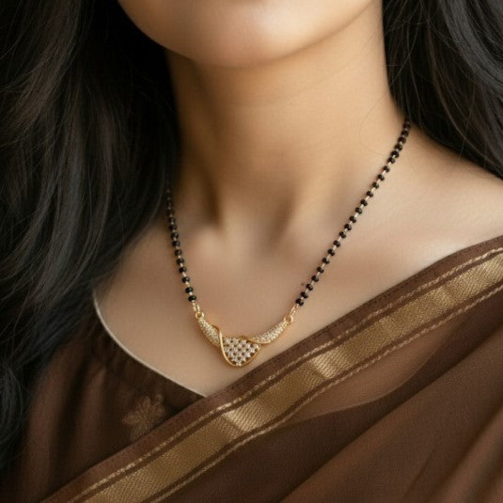 Woman wearing a gold necklace with a brown saree
