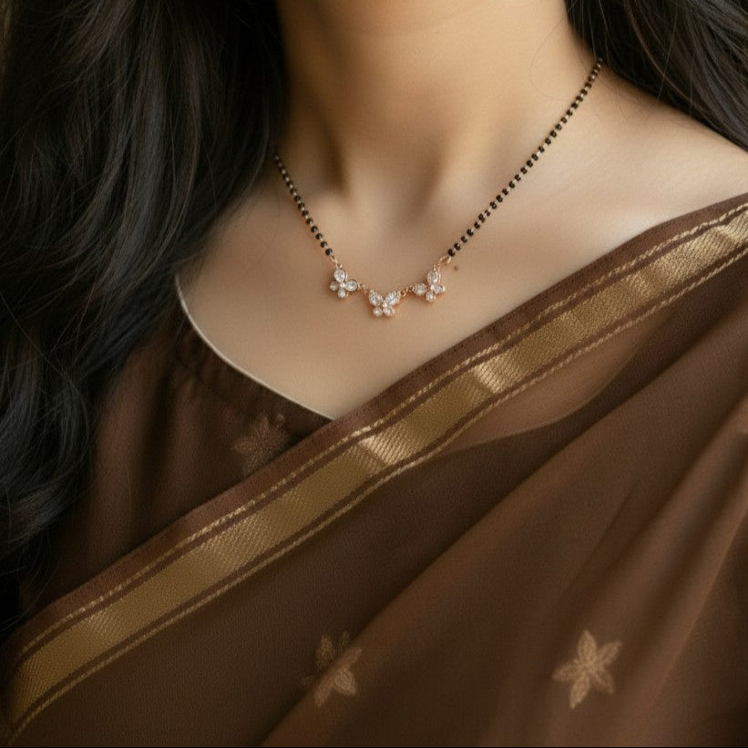 Close-up of a woman wearing a brown saree with a delicate necklace.