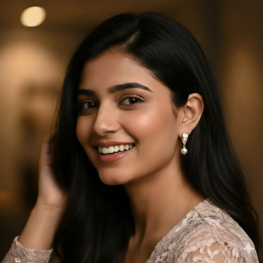 Woman with dark hair and earrings smiling against a blurred background