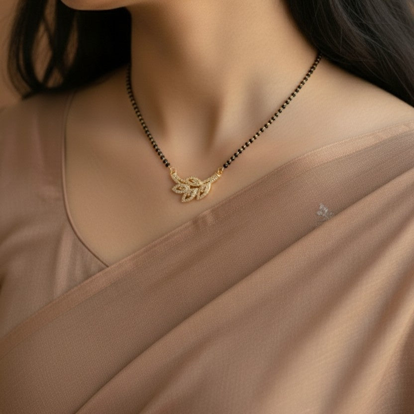 Close-up of a gold necklace with a pendant on a beige garment