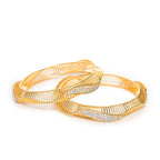 Two gold bangles with intricate designs on a white background