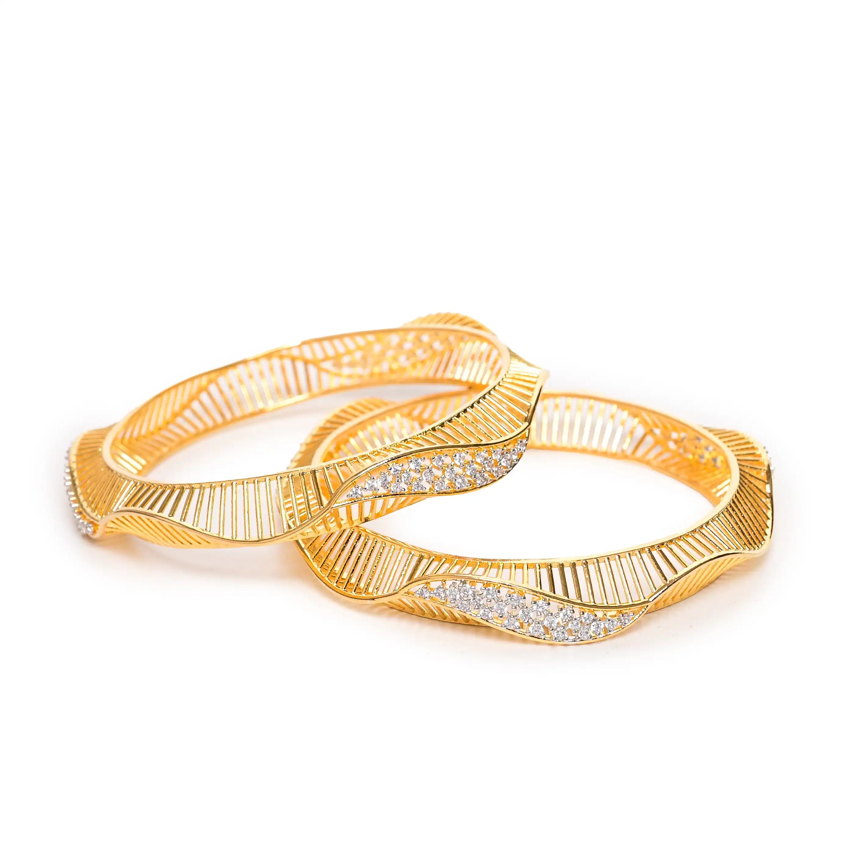 Two gold bangles with intricate designs on a white background