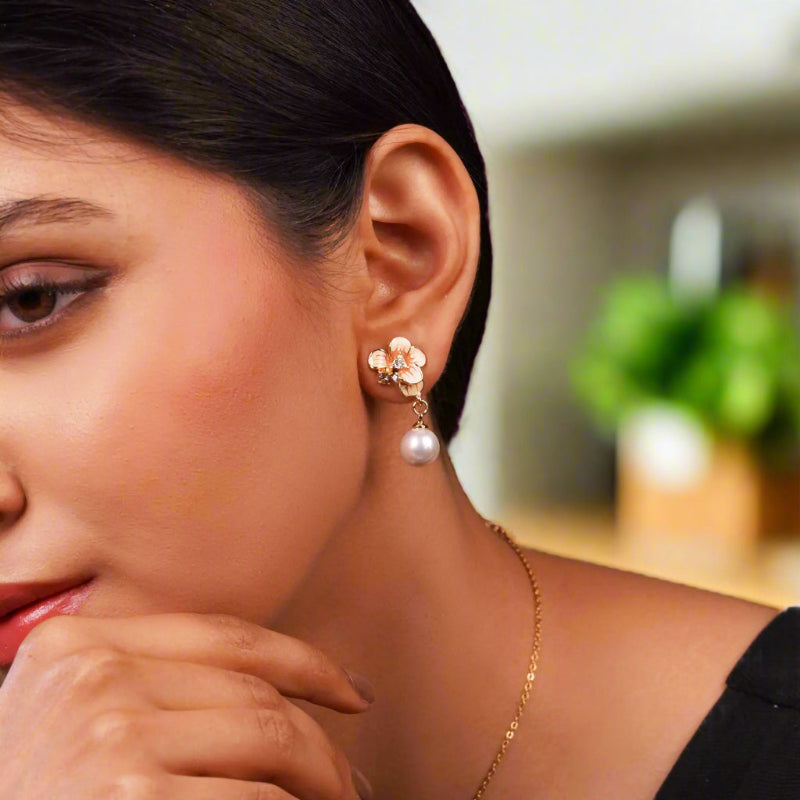 Stylish floral pearl drop earrings for women – gold-plated designer fashion jewellery with enamel finish and crystal stones, perfect for wedding, festive and party wear.