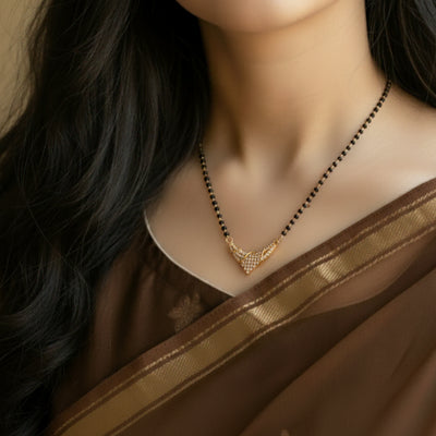 Gold necklace on a mannequin with a brown saree