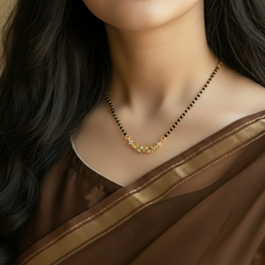 Woman wearing a gold necklace with a brown saree