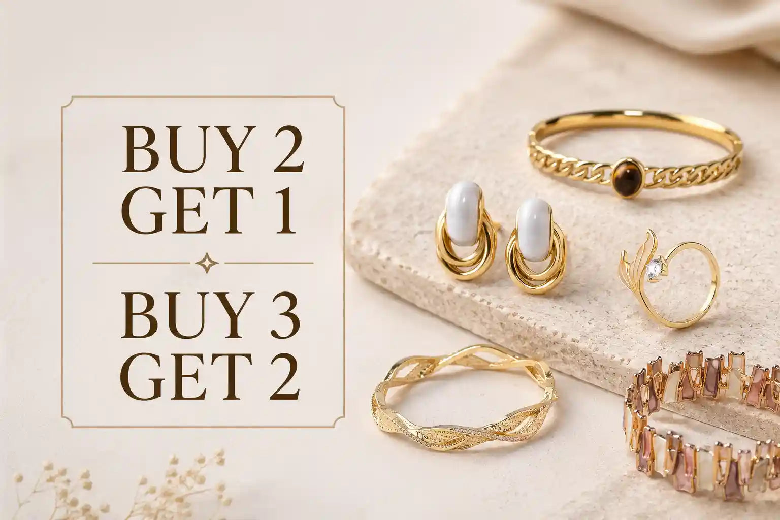 A promotional jewelry arrangement on a light beige surface with text reading 'BUY 2 GET 1' and 'BUY 3 GET 2'. Visible items include multiple gold rings, a pair of gold earrings with white oval stones, and a gold bracelet with pinkish faceted stones. Own It Pure Jewelry