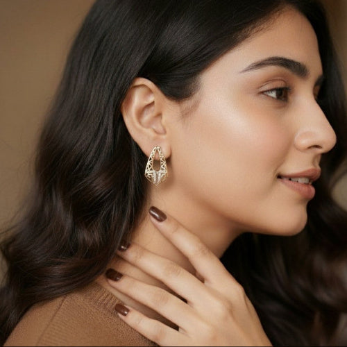 Woman wearing elegant earrings with a neutral background