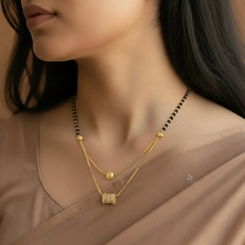 Woman wearing a gold necklace with a close-up focus on the jewelry.