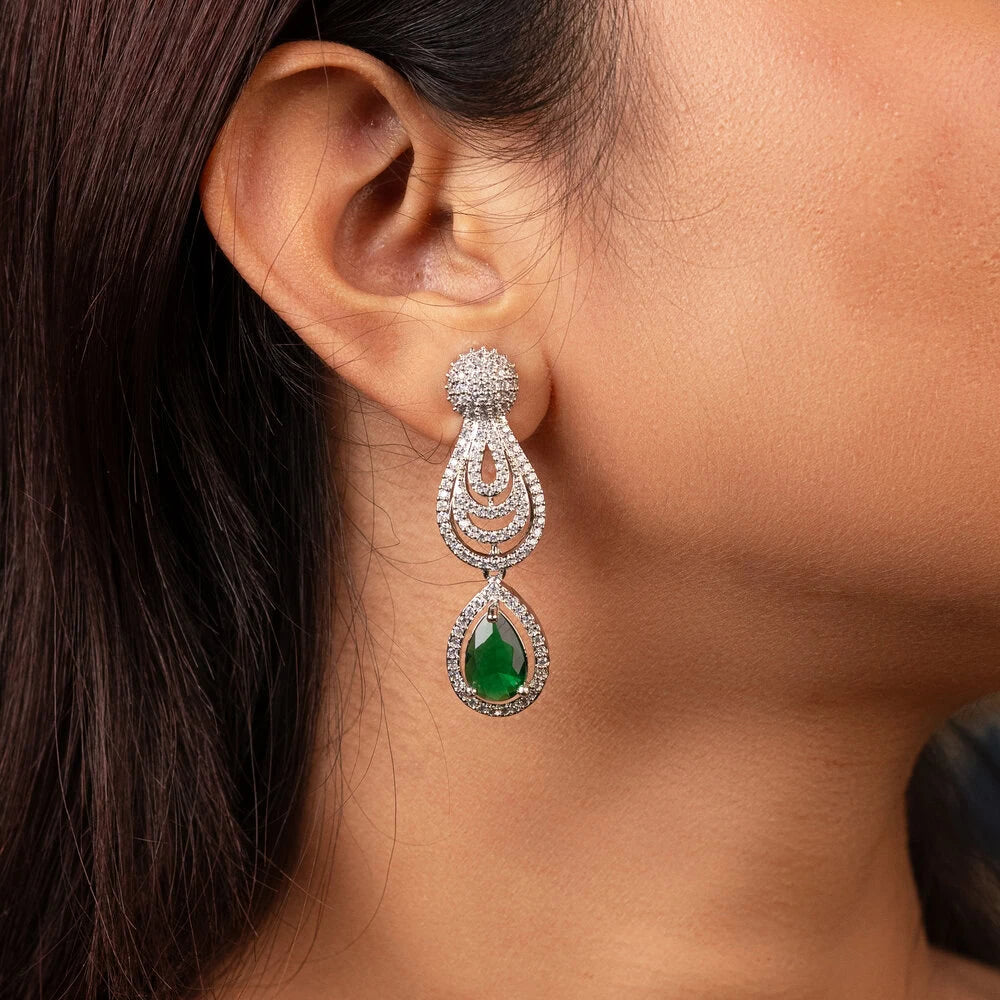 Close-up of a woman wearing a green gemstone earring.