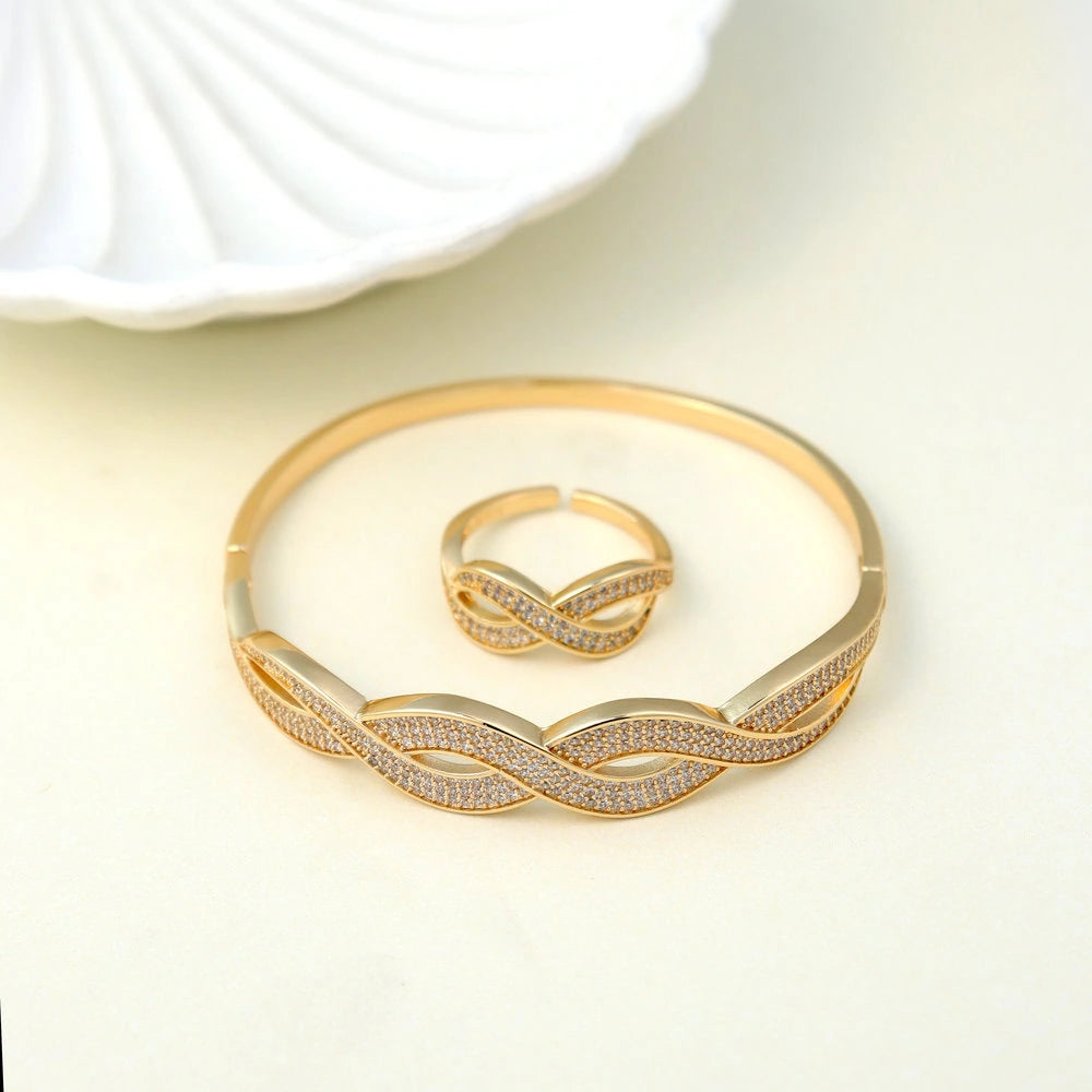 Gold bracelet and ring set on a light background