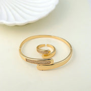 Gold bracelet and ring set on a light background