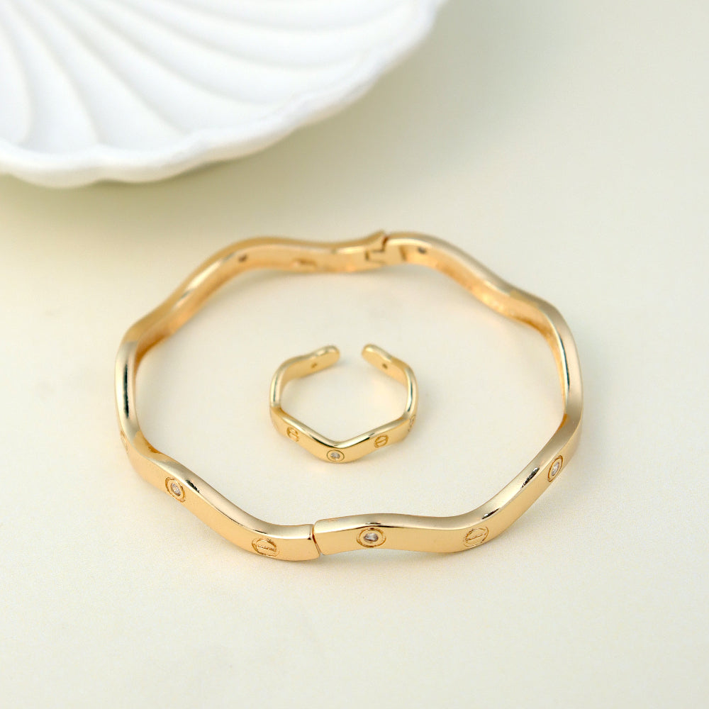Modern gold-plated bangle and open cuff ring set featuring a sleek, wavy design with subtle embedded crystals. A perfect minimalist jewelry piece for everyday wear, office fashion, and trendy casual looks. wavy bangle bracelet, crystal-studded ring, minimalist gold jewelry, contemporary fashion accessories.