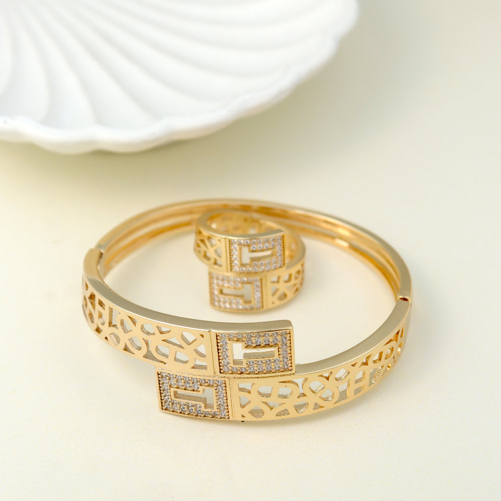 Exquisite gold-plated bangle and ring set with intricate latticework and sparkling cubic zirconia embellishments. A perfect blend of traditional elegance and modern statement jewelry for weddings, festive occasions, and luxury gifting.filigree bracelet, adjustable statement ring, ethnic-inspired jewelry, bridal bangle set.