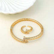 Gold bracelet and ring set on a light background