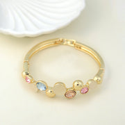 Elegant gold bracelet with colorful gemstones and mother-of-pearl accents, featuring a chic bangle design. Perfect luxury jewelry for fashion and gift ideas. (Unique keywords: gemstone bangle, mother-of-pearl jewelry