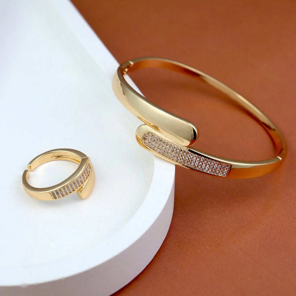 Gold bracelet and ring on a white and brown background