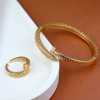 Gold bracelet and ring on a white and brown background