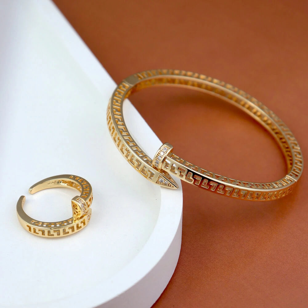 Gold bracelet and ring on a white and brown background