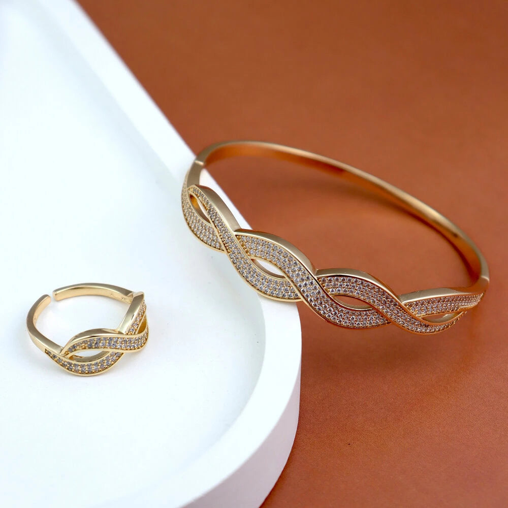 Gold bracelet and ring set on a white and brown background