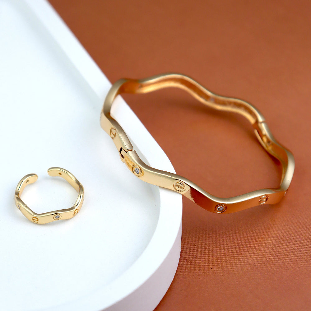 Modern gold-plated bangle and open cuff ring set featuring a sleek, wavy design with subtle embedded crystals. A perfect minimalist jewelry piece for everyday wear, office fashion, and trendy casual looks. wavy bangle bracelet, crystal-studded ring, minimalist gold jewelry, contemporary fashion accessories.