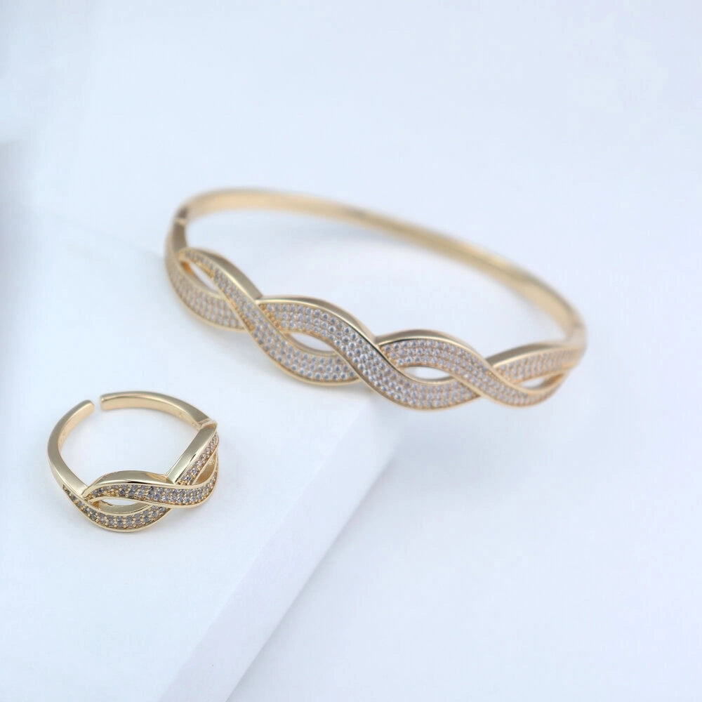 Gold bracelet and ring set on a light background
