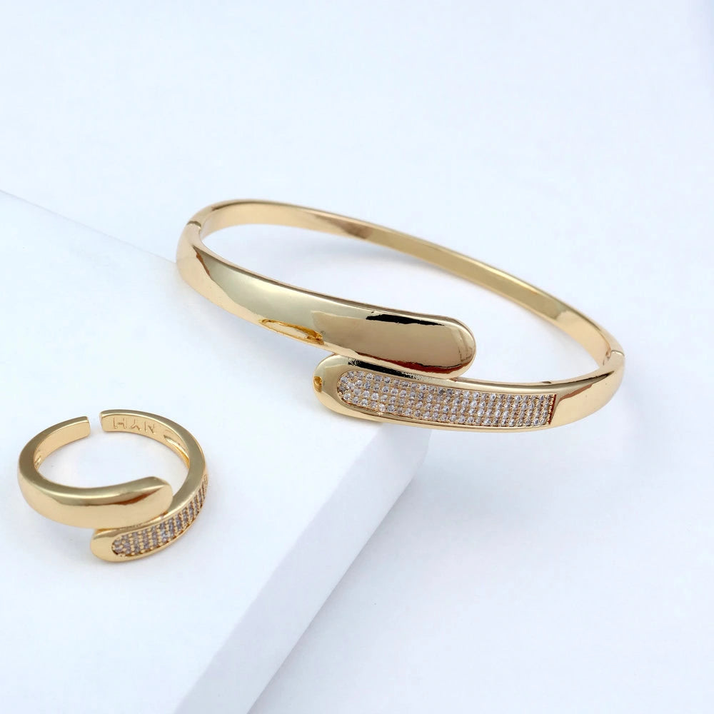 Gold bracelet and ring set on a light background