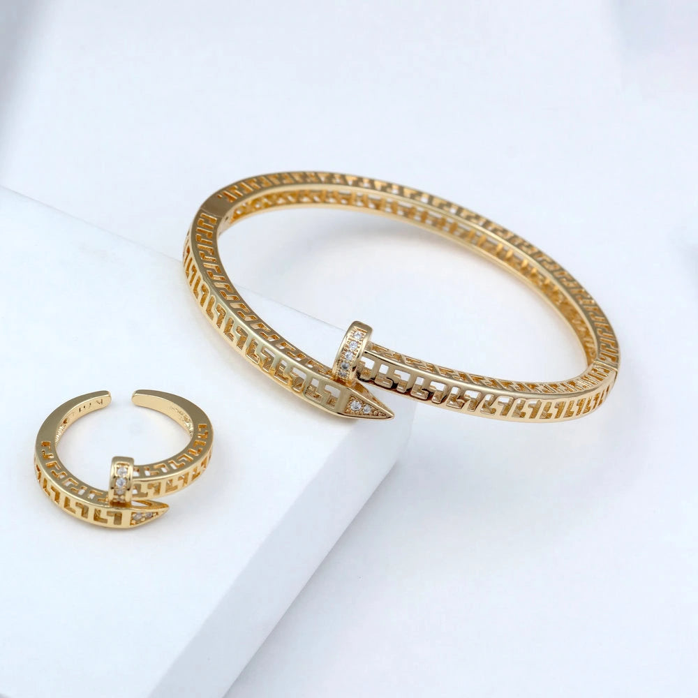 Gold bracelet and ring set on a white surface