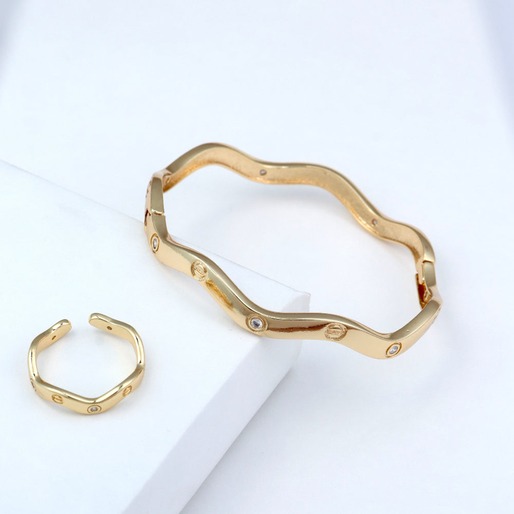 Modern gold-plated bangle and open cuff ring set featuring a sleek, wavy design with subtle embedded crystals. A perfect minimalist jewelry piece for everyday wear, office fashion, and trendy casual looks. wavy bangle bracelet, crystal-studded ring, minimalist gold jewelry, contemporary fashion accessories.