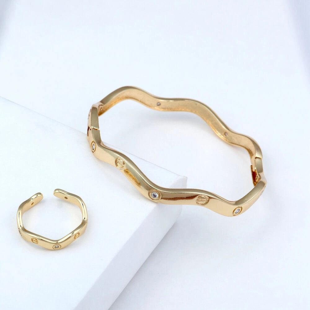 Gold bracelet and ring on a white background