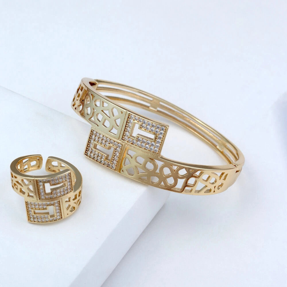 Gold bracelet and ring with geometric design on a white background