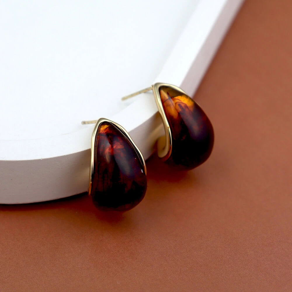 Tortoiseshell earrings with gold accents on a white surface