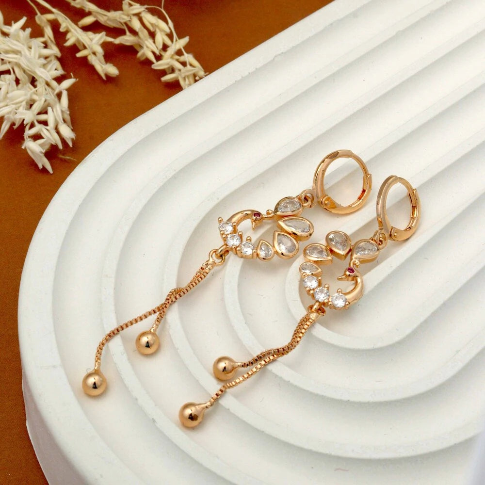 Gold jewelry set with earrings on a white surface