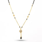 Gold necklace with black beads on a white background