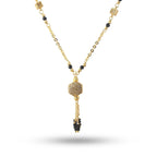 Gold necklace with black beads on a white background