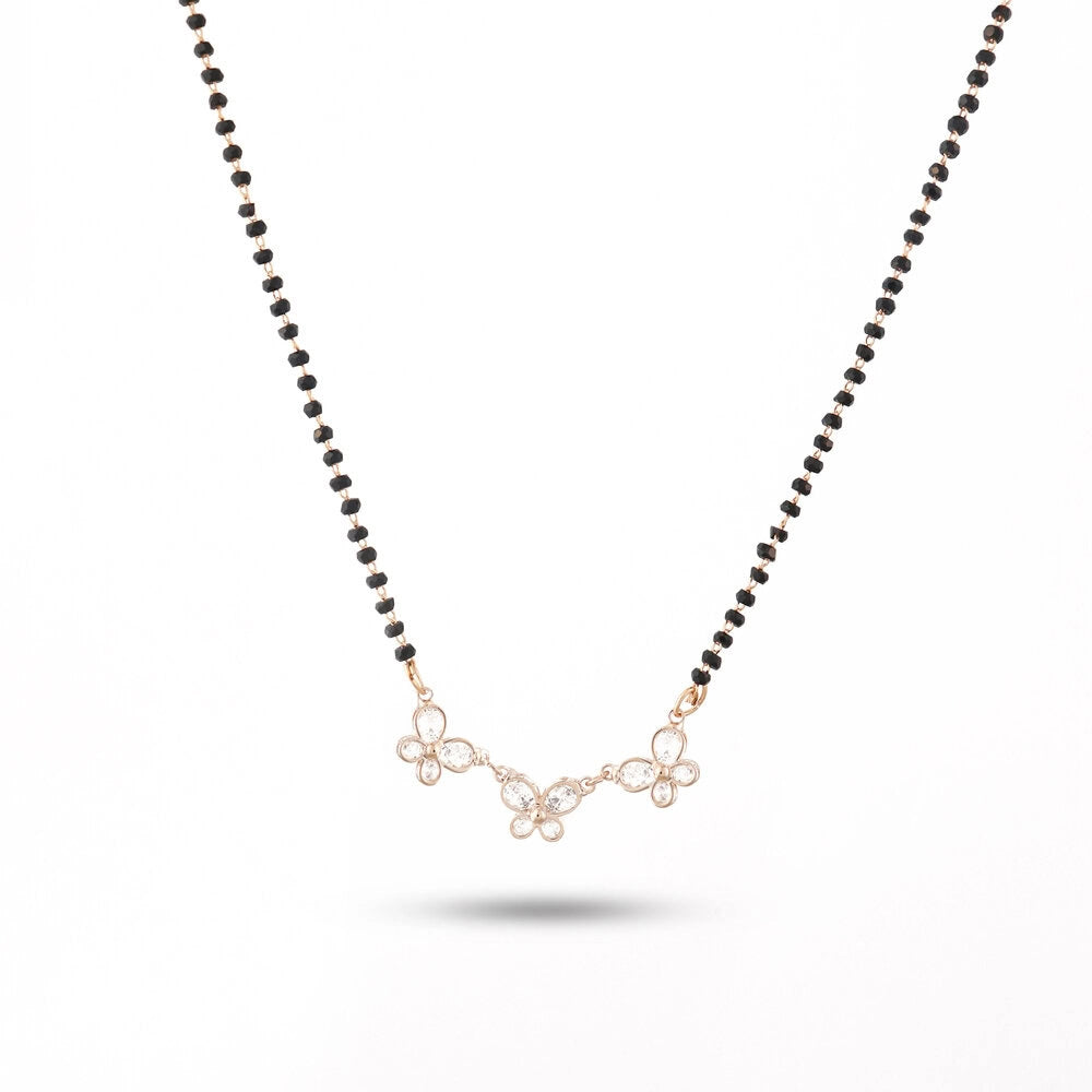 Necklace with black beads and a gold floral pendant on a white background