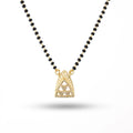 Necklace with black beads and a gold pendant on a white background