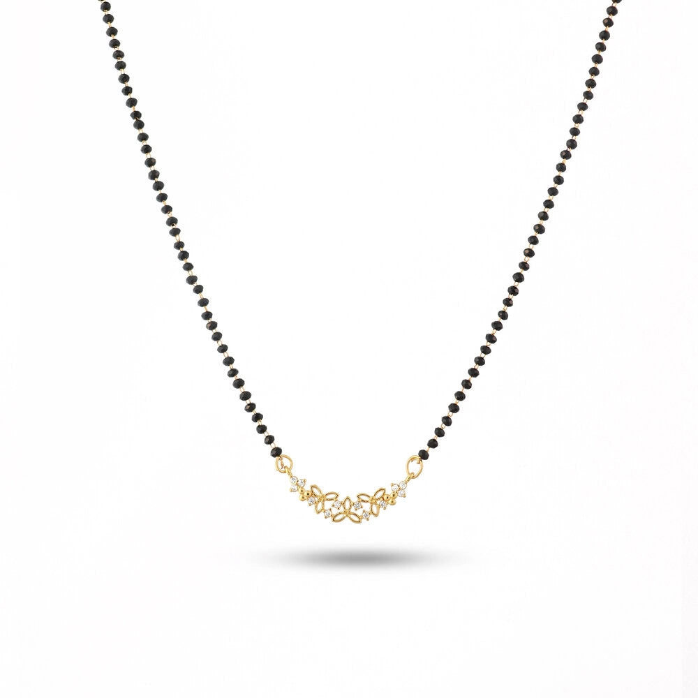 Necklace with black beads and a gold clasp on a white background