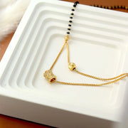 Gold necklace with a decorative clasp on a white dish