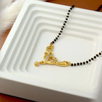 Gold necklace with a heart pendant on a white tray