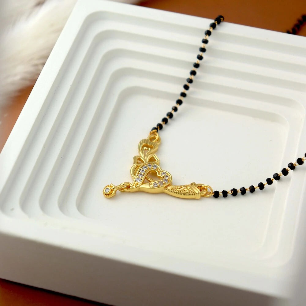 Gold necklace with a heart pendant on a white tray