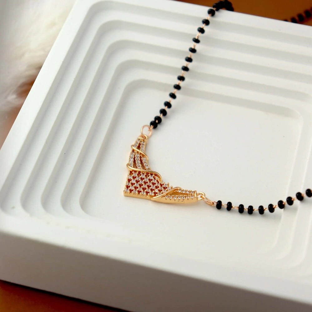 Necklace with a gold shoe pendant on a white dish