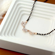 Necklace with black beads and rose gold accents on a white dish