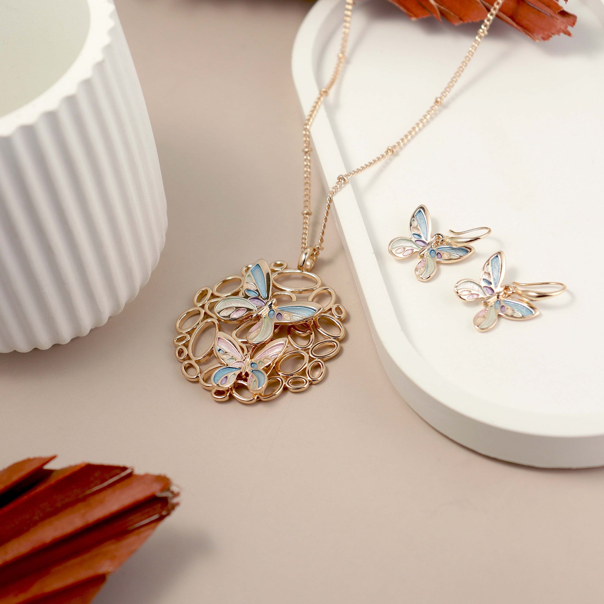 Butterfly-themed jewelry set on a neutral background