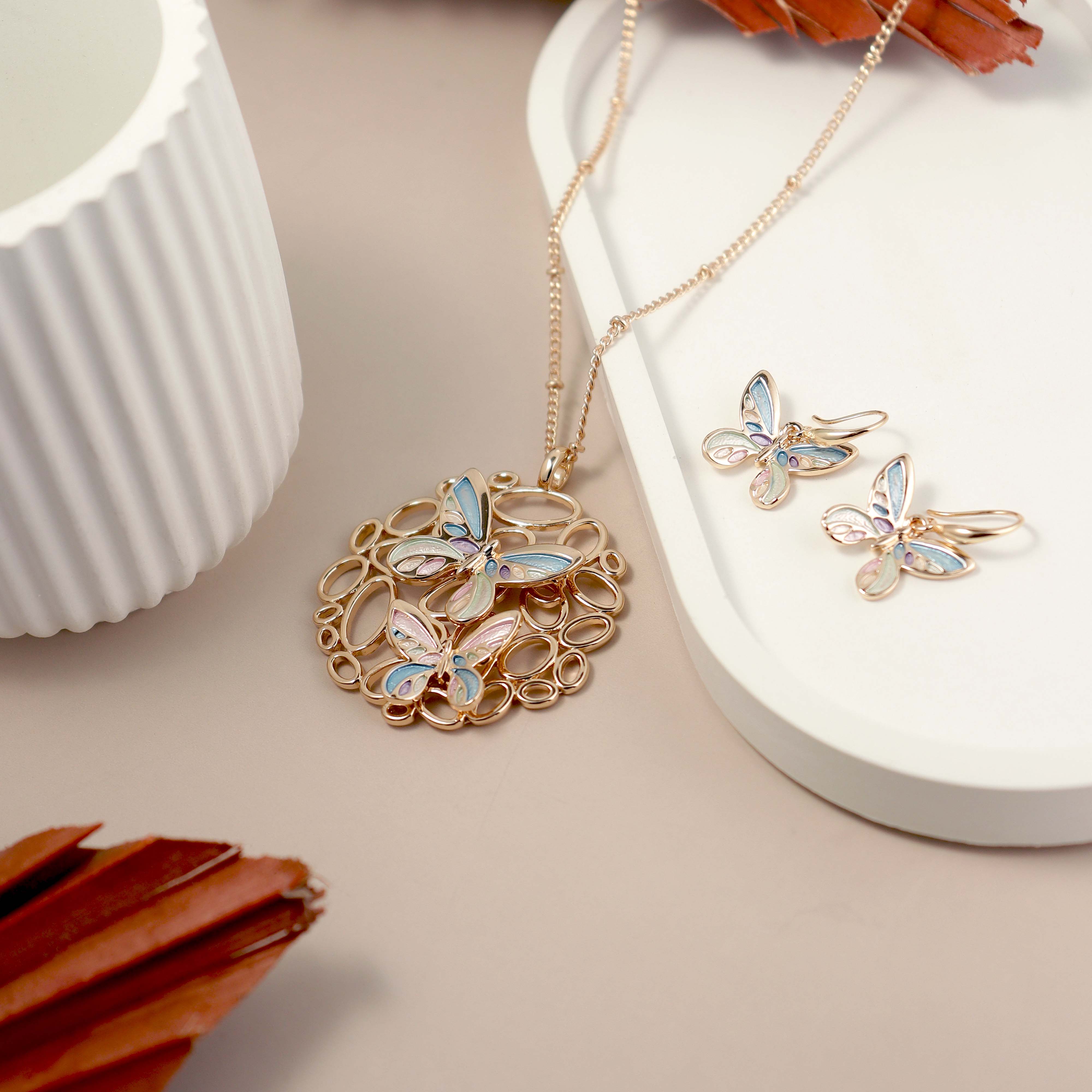 Butterfly-themed jewelry set on a neutral background