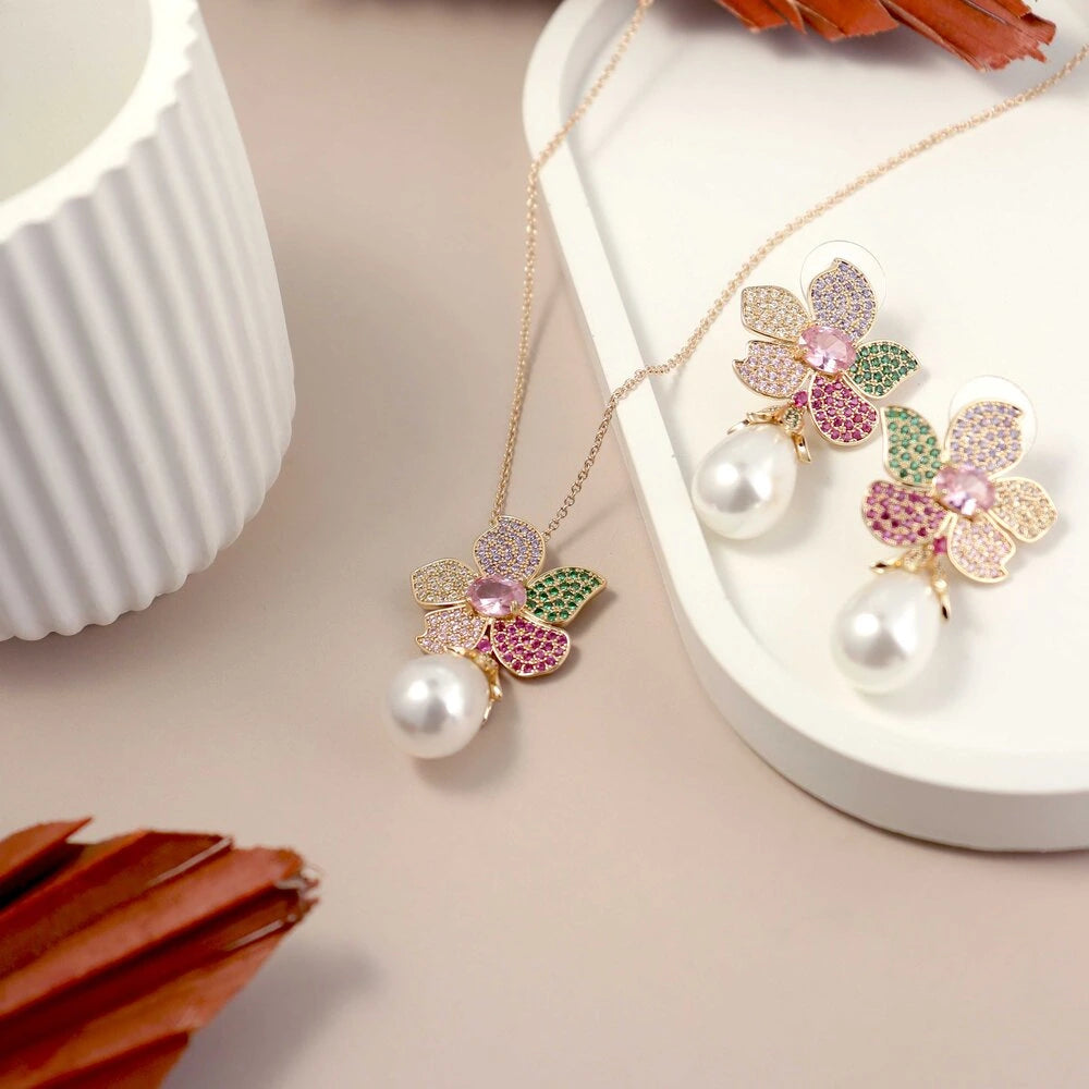 Jewelry set with floral design and pearls on a beige surface