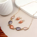 Jewelry set with leaf-shaped pendants on a light surface