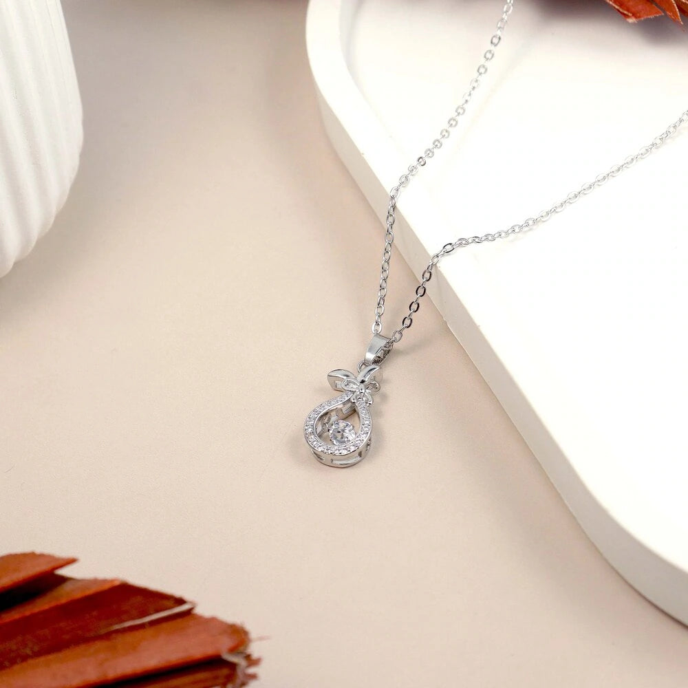 Silver necklace with a teardrop-shaped pendant on a light surface.