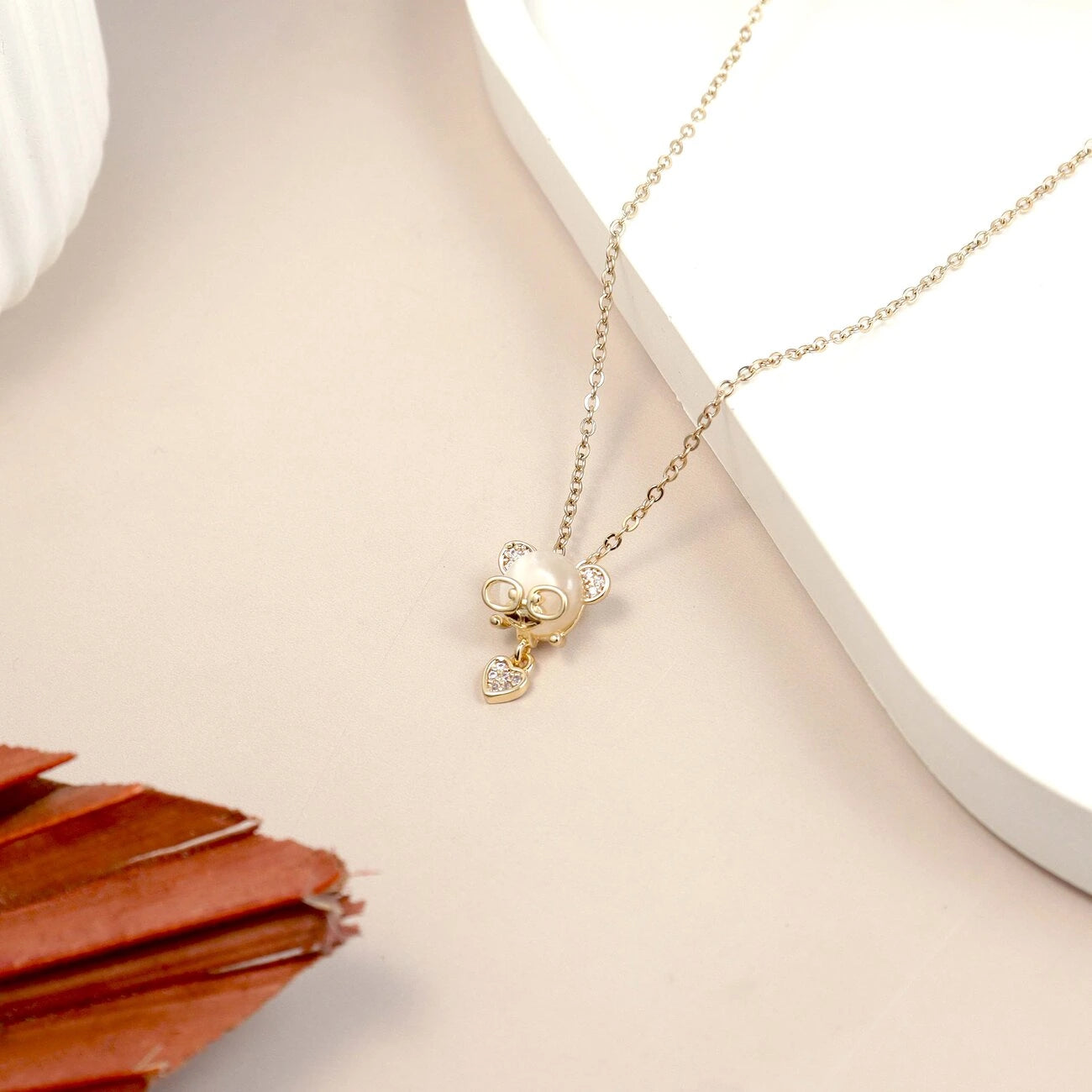 Gold necklace with a pendant on a light surface